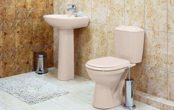 Cuvette de toilette beige sur fond de grès cérame de couleur appropriée