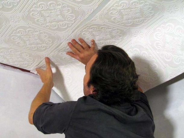 Coller du papier peint intissé sur la surface du plafond