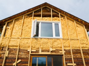 Nous construisons une maisonIsolation d'une maison en bois à l'extérieur avec du plastique mousse avec nos propres mains sous le revêtement