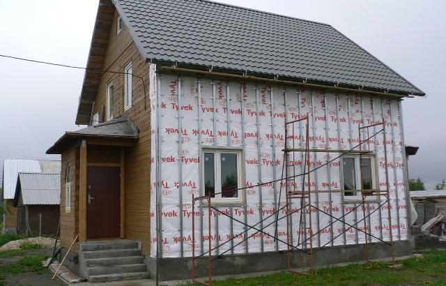 Nous construisons une maisonIsolation d'une maison en bois à l'extérieur avec du plastique mousse avec nos propres mains sous le revêtement